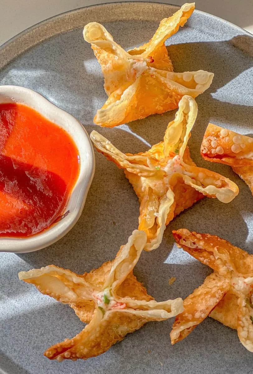 Fried crab rangoon shaped like little stars with dipping sauce