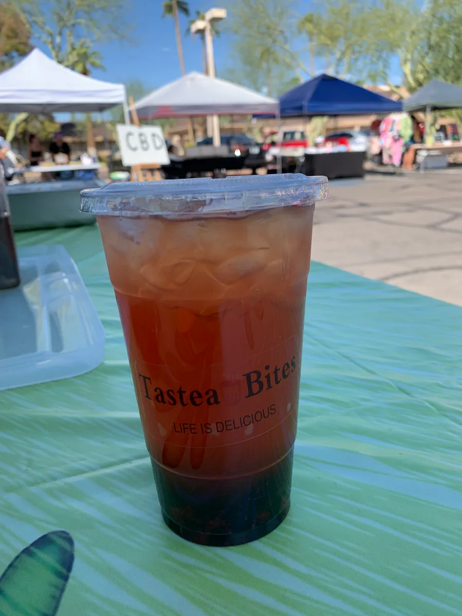 Red-pink strawberry green tea over ice in a Tastea Bites cup