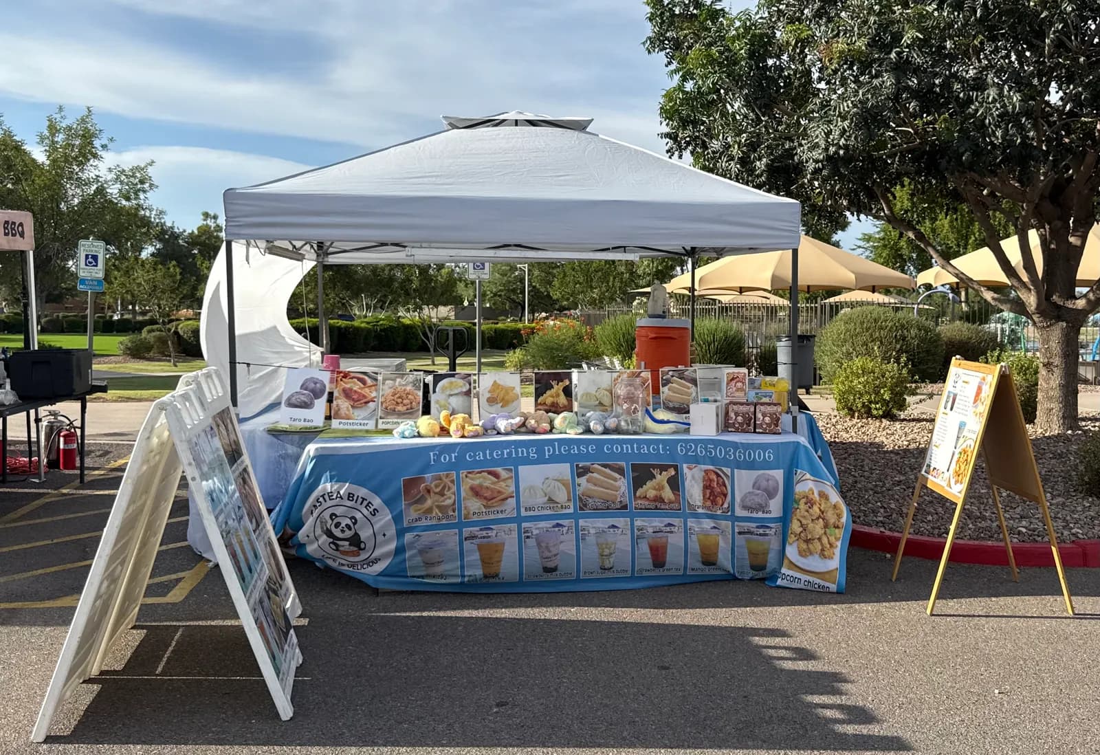 The Tastea Bites tent set up at a Phoenix-area market, A-frame menu boards out front